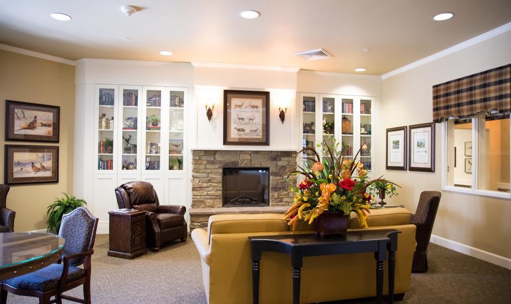 A cozy living room with a fireplace, elegant decor and comfortable seating.