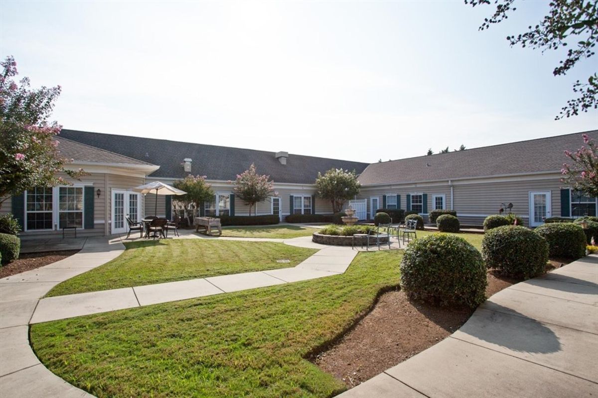 A well-maintained courtyard with a lawn, pathways, and outdoor seating.
