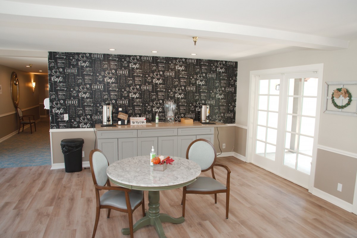 A modern kitchen dining area featuring a round table, chairs, and a chalkboard wall.