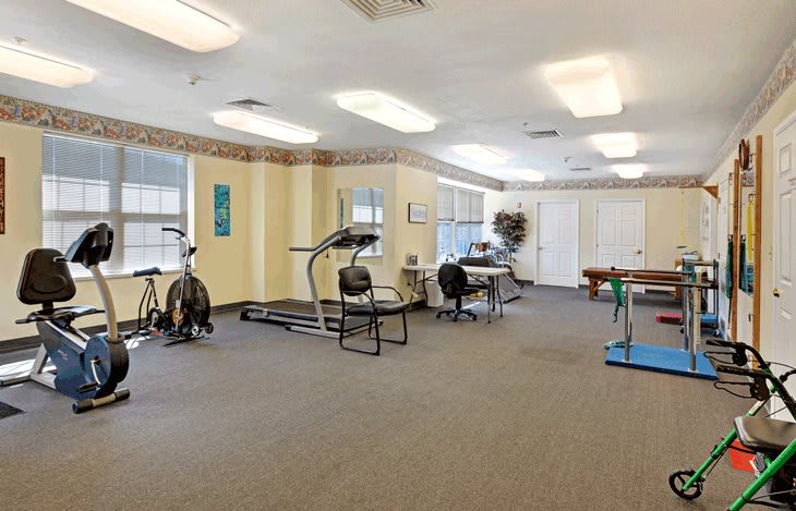 A fitness room featuring a treadmill, stationary bike, and other exercise equipment.