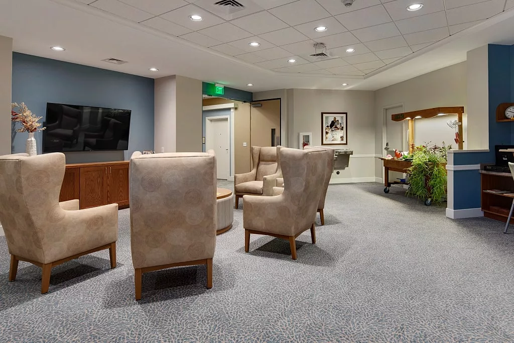 A comfortable waiting room with upholstered chairs and a television.