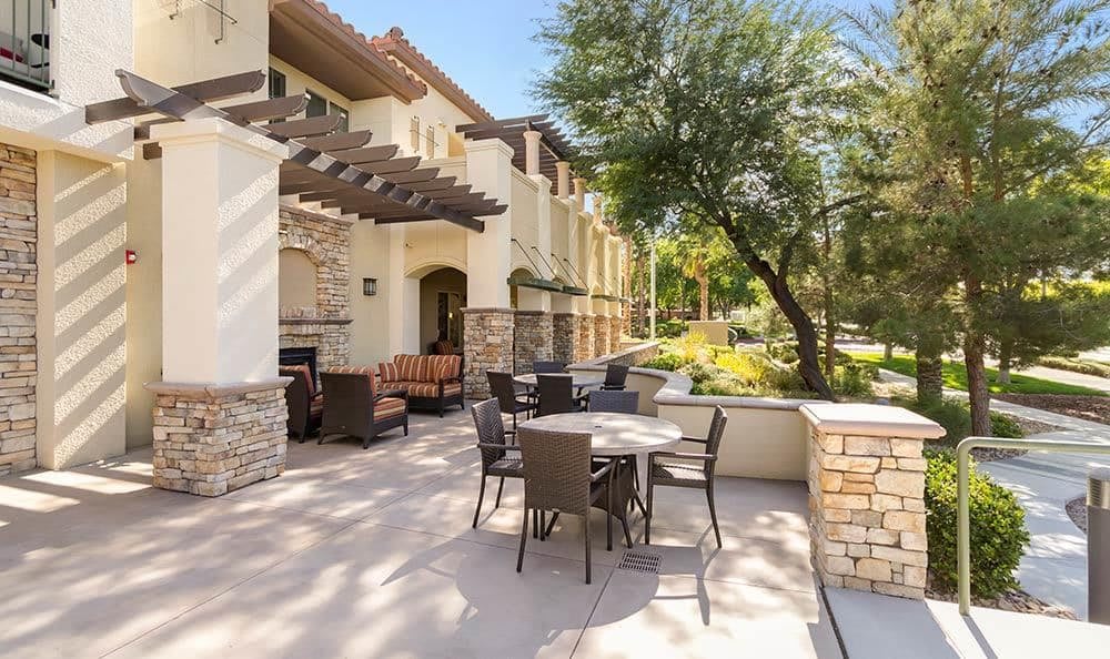 A sunny outdoor patio area with seating arrangements and a view of the surrounding landscape.