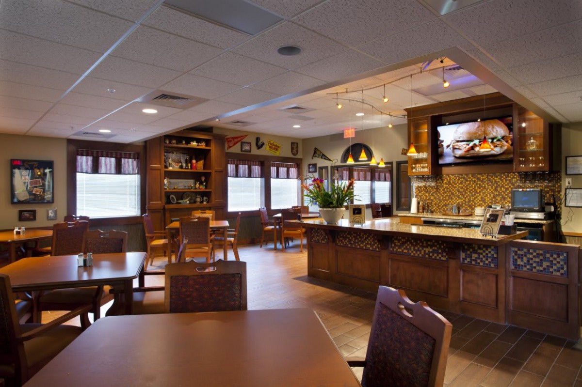 An empty restaurant interior with wooden furniture and warm lighting.