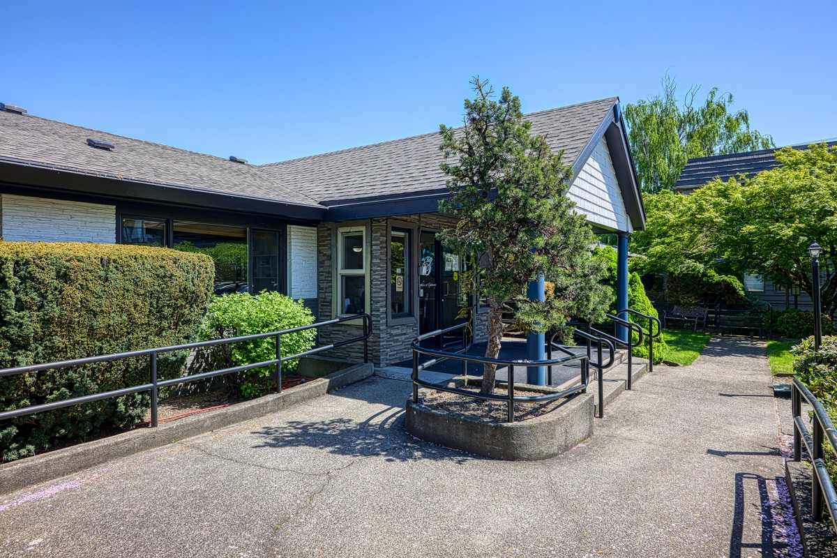 A small building with a landscaped entrance and accessible ramp.