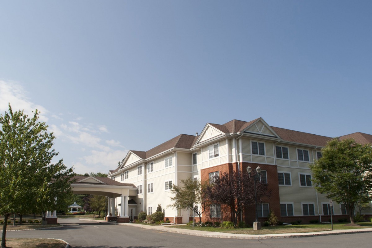 A residential building with a covered entrance under a clear blue sky.