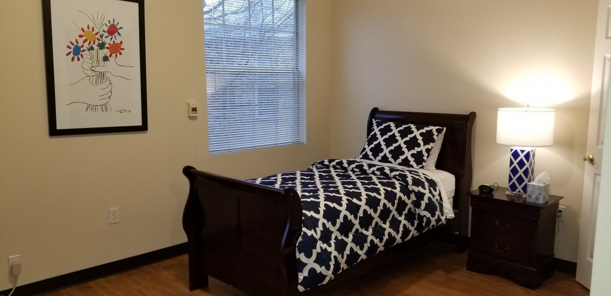 A simple bedroom with a single bed next to a window.