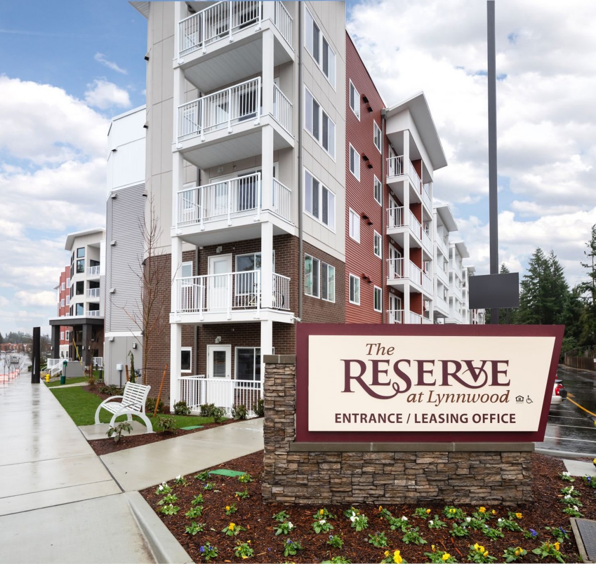 Modern residential apartment complex with signage at the entrance.