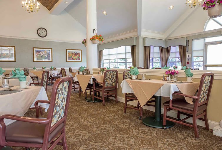 A spacious and elegant dining room with neatly arranged tables and chairs.
