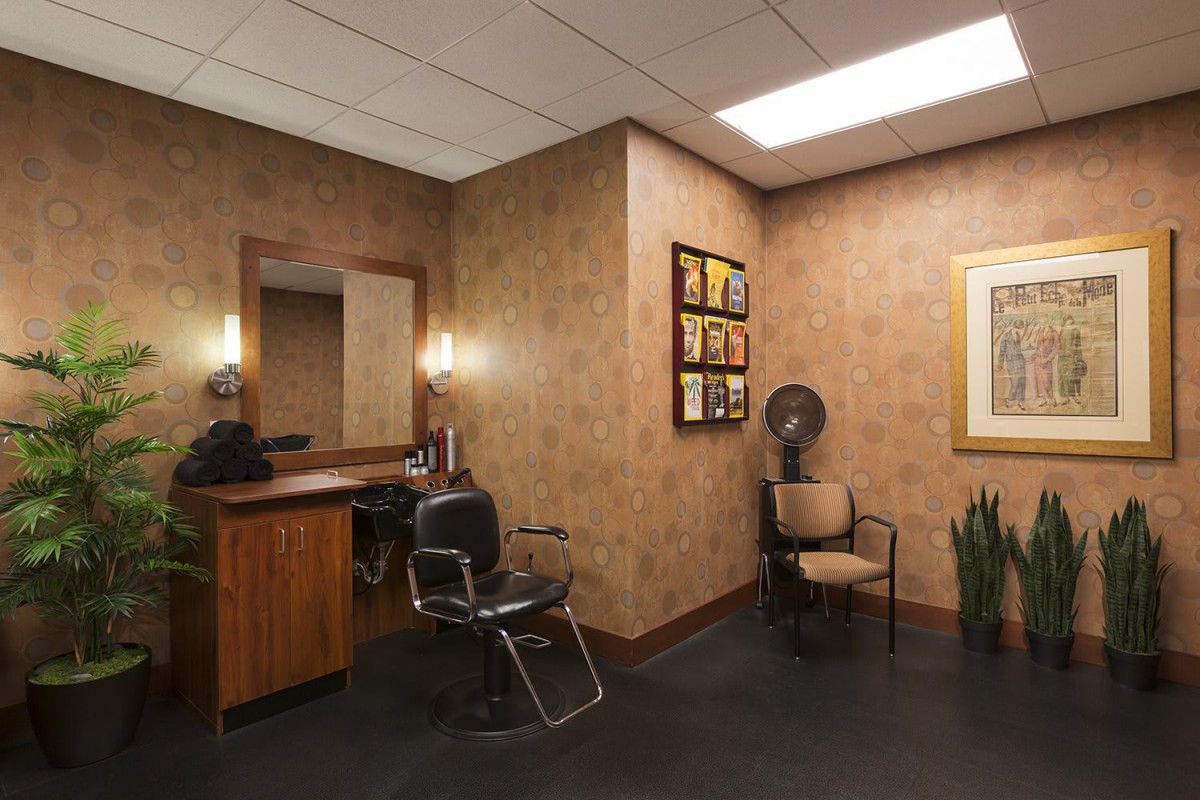 A cozy hair salon interior with styling stations and a waiting area.
