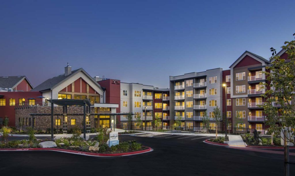 A modern apartment complex illuminated at night.