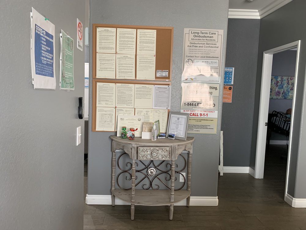 A view of an office hallway featuring a bulletin board filled with notices and a small table displaying pamphlets.