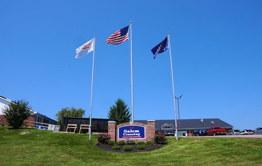 Flags waving proudly in front of a building under a clear blue sky.