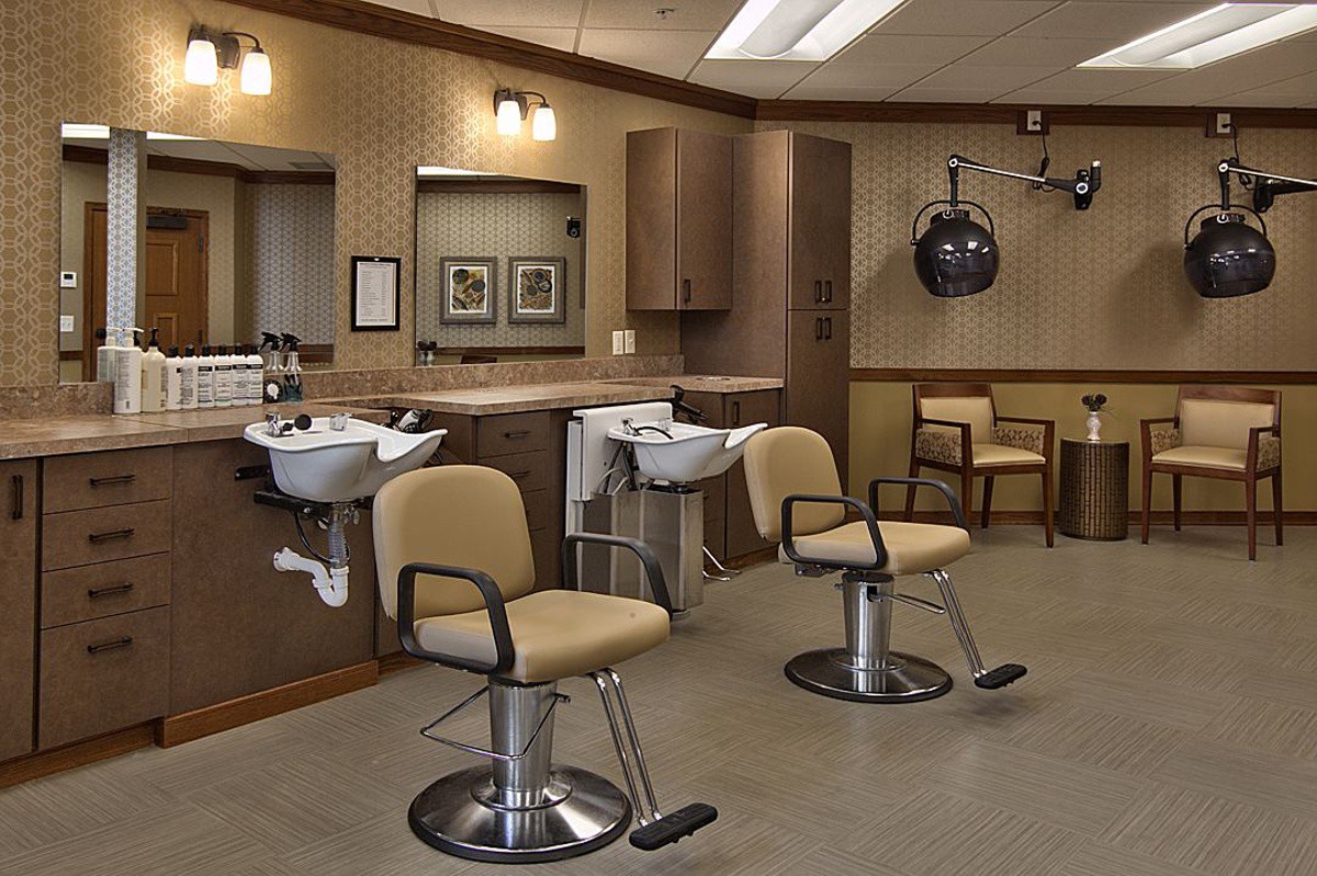 An interior view of a barber shop featuring chairs, mirrors, and sinks.