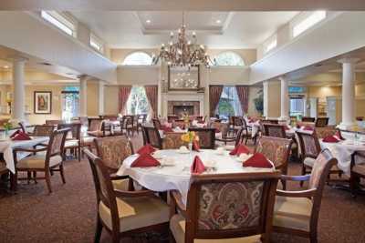 An elegant dining room with neatly arranged tables and a chandelier.
