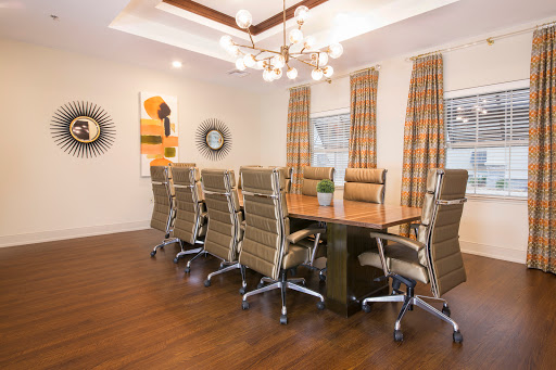 A modern conference room featuring a wooden table surrounded by stylish chairs and decorative elements.