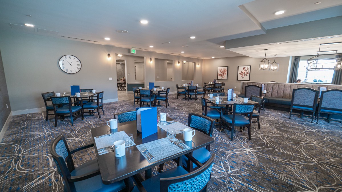 An indoor dining area with neatly arranged tables and chairs, featuring modern decor.