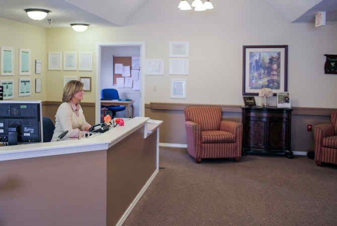 Reception area in an office setting with a receptionist at the desk.