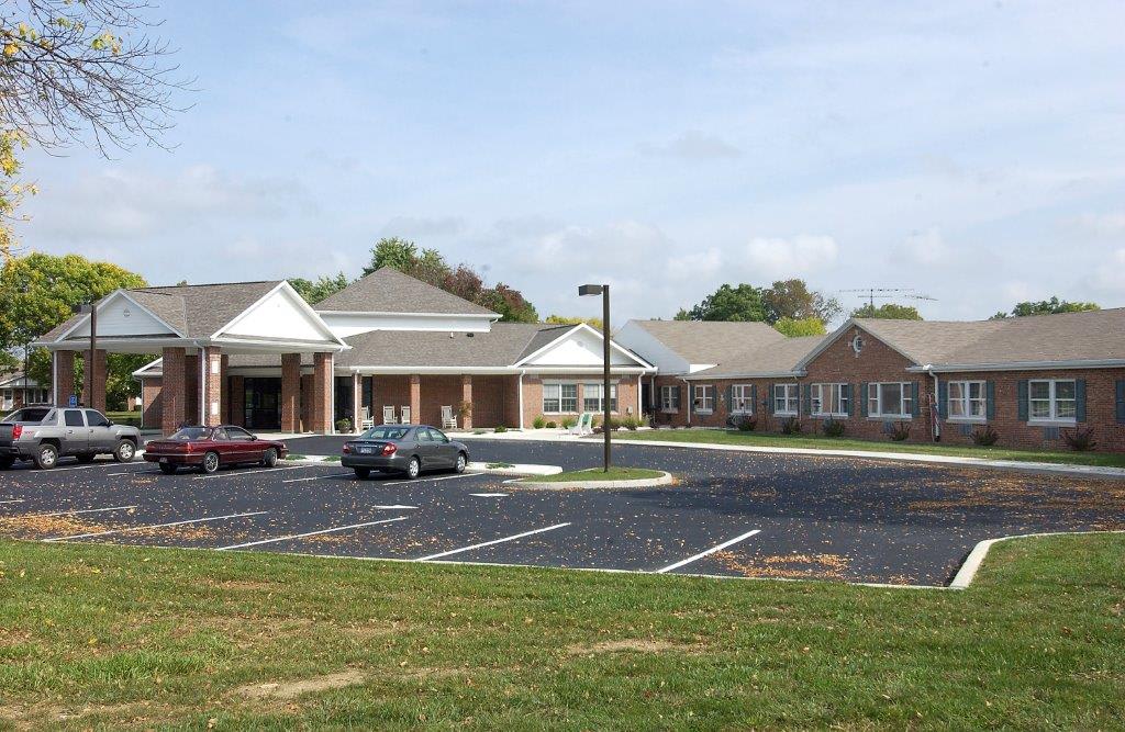A suburban building with a parking lot and several parked cars.