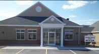 A commercial building with large windows and a central entrance.