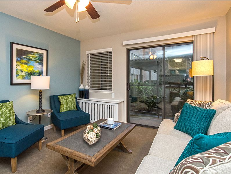 A modern living room with blue accents featuring a sofa, armchairs, and a coffee table.