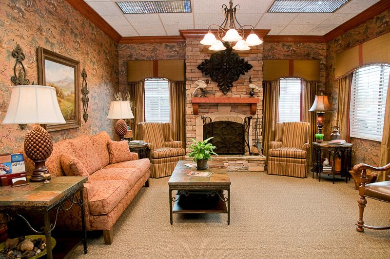 A cozy living room with a fireplace, sofas, and warm lighting.