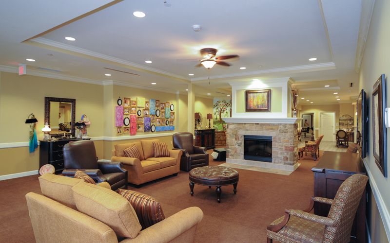 A cozy living room with comfortable seating, a fireplace, and colorful artwork on the wall.