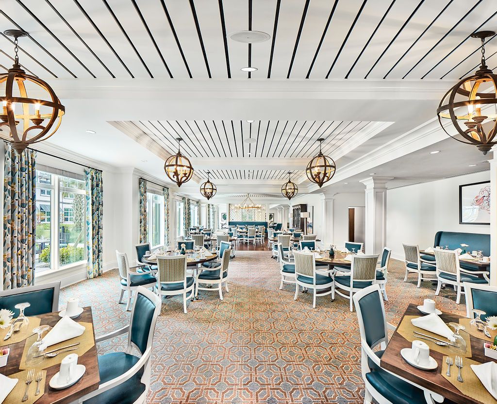 A modern dining room with elegant decor, featuring stylish tables, chairs, and unique lighting fixtures.
