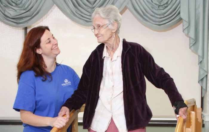 A caregiver assists an elderly woman, providing support and companionship.