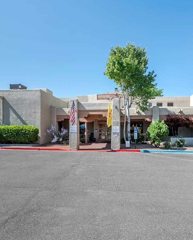 The exterior view of a hotel entrance with a clear blue sky.