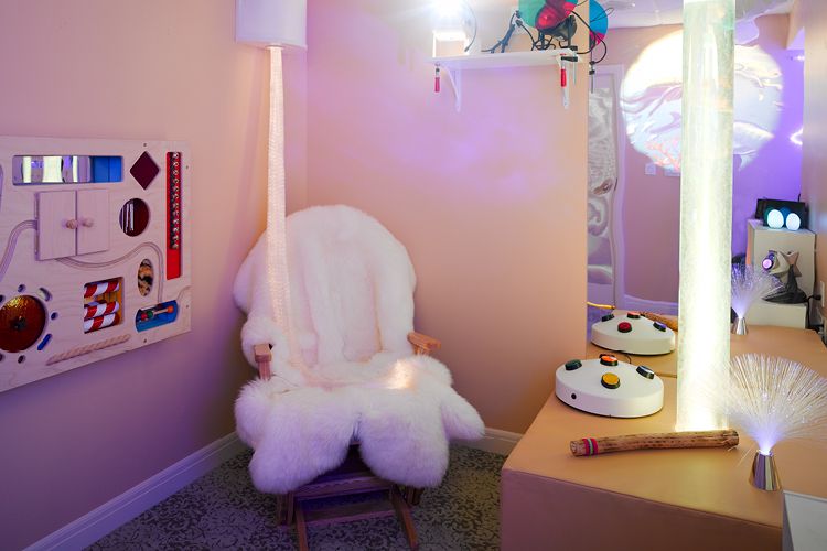A creatively designed room featuring a fluffy chair, unique lighting, and modern decor elements.