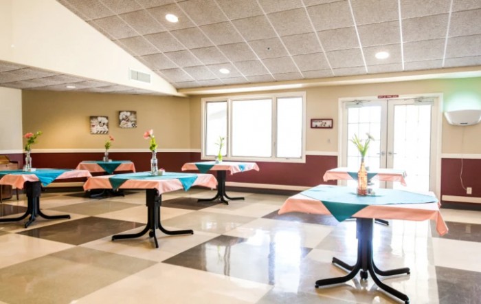 A bright and spacious dining area with neatly arranged tables and chairs.