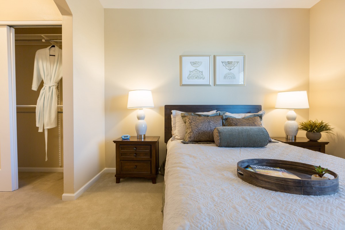 A cozy and elegantly decorated bedroom with two nightstands and lamps.