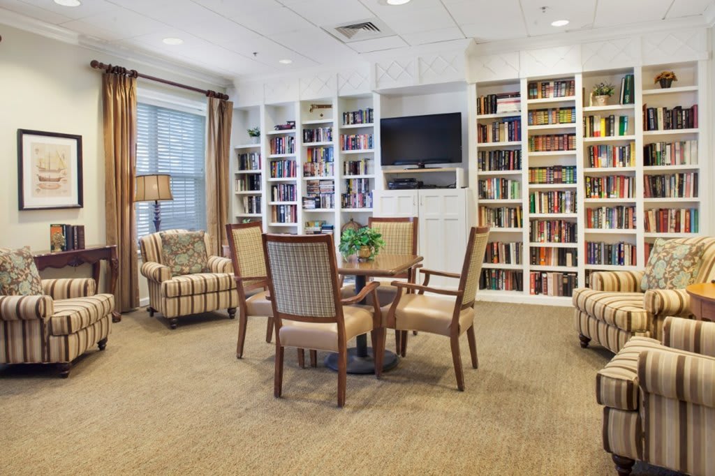 A cozy reading room with bookshelves, a television, and seating area.