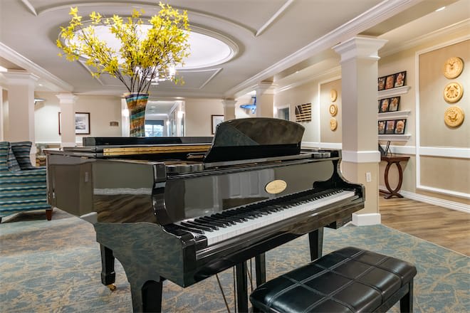 A luxurious music room featuring a grand piano and elegant interior design.