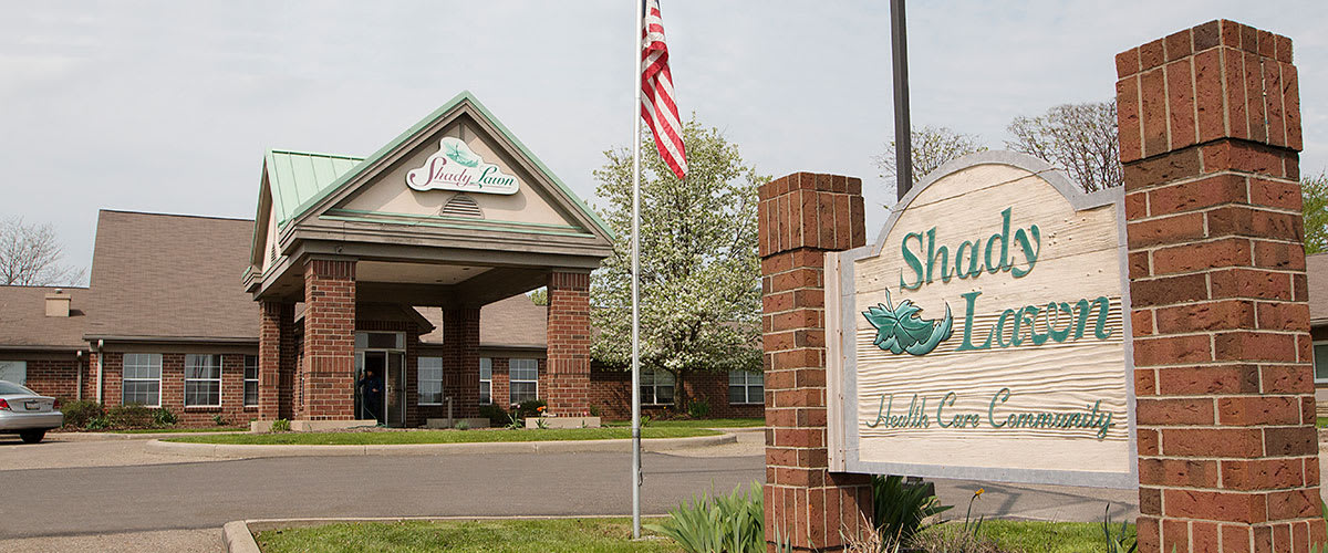 Entrance of a building with an American flag and a sign.