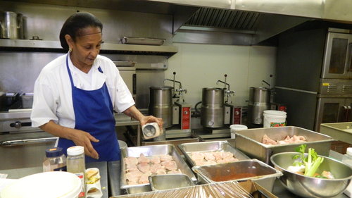 A chef prepares ingredients in a busy kitchen, showcasing the art of food preparation.