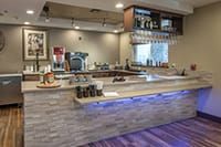 A modern bar interior with a variety of beverages and a coffee machine.