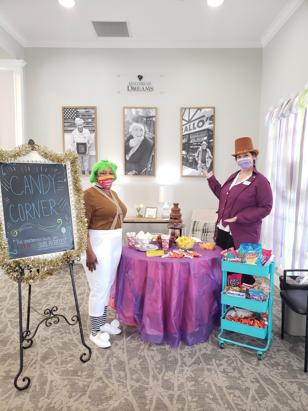 A colorful themed setup featuring characters in costumes with a table of candy and a chocolate fountain.
