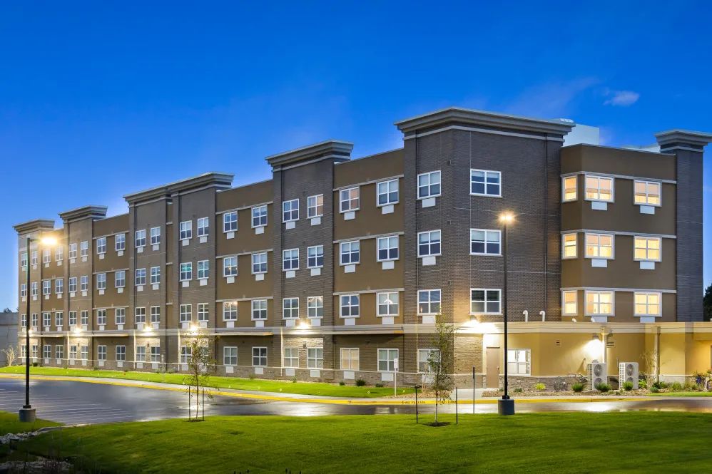 A modern residential apartment building illuminated at night.