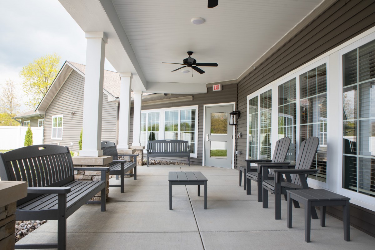 A spacious and inviting covered patio with comfortable outdoor seating and a ceiling fan.