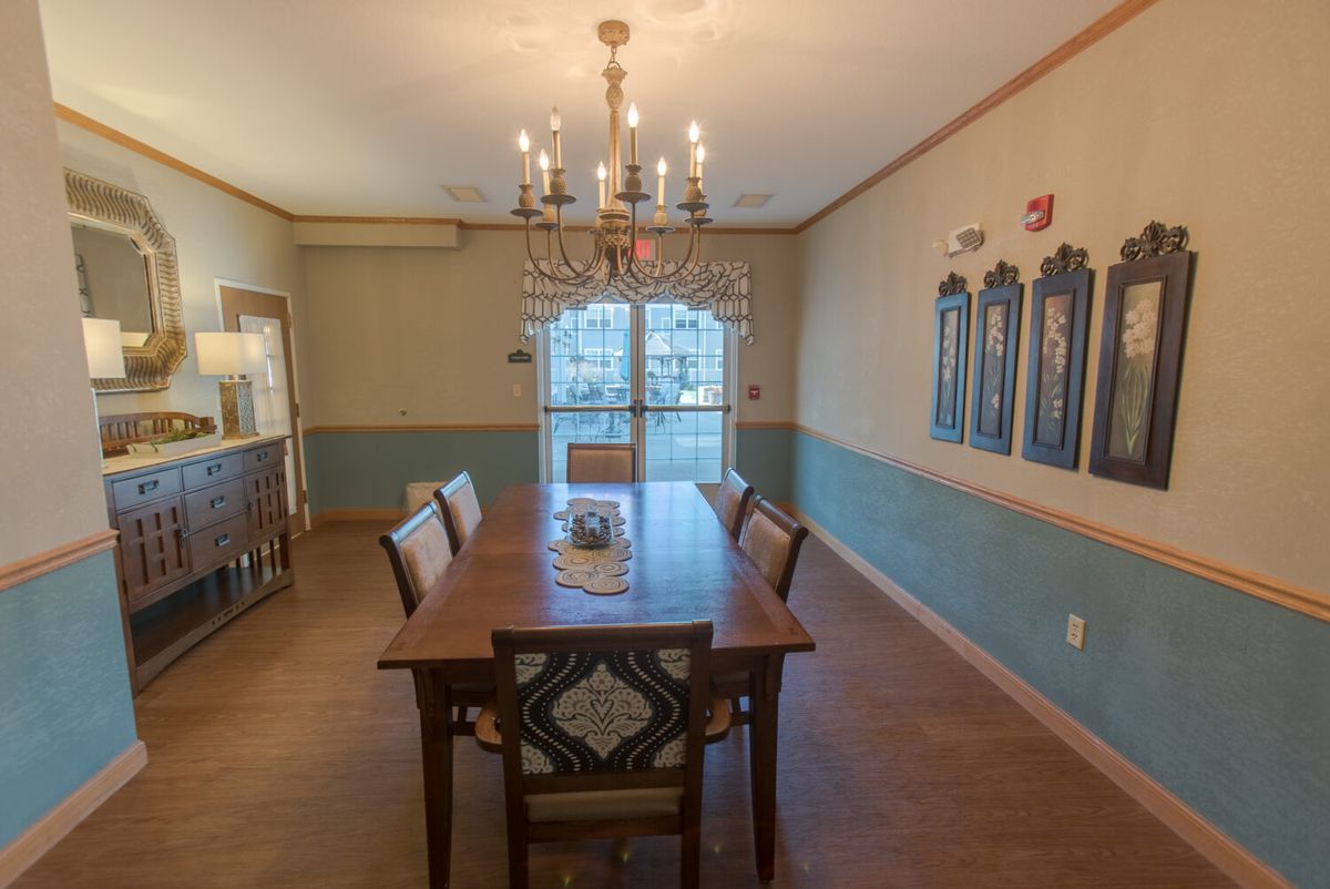 A well-decorated dining room featuring a wooden table, upholstered chairs, and a chandelier.