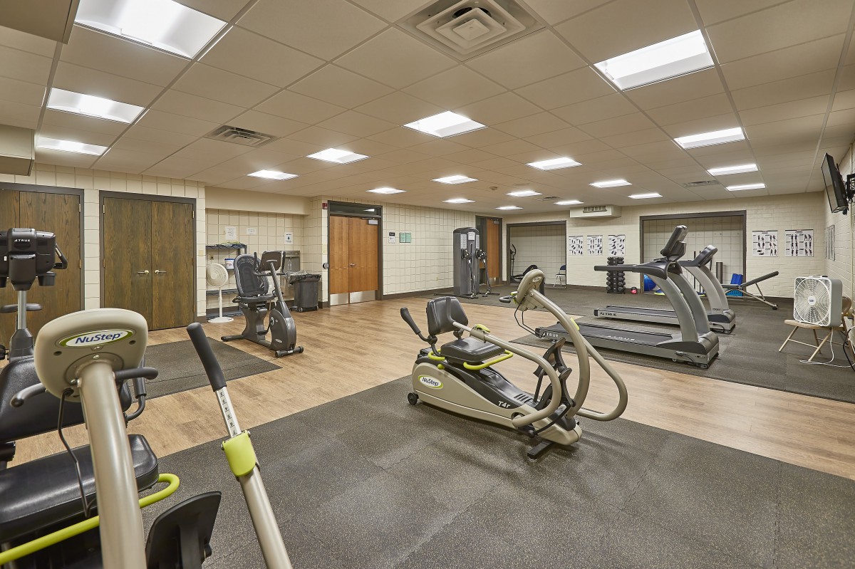 A modern gym with various exercise equipment including treadmills and stationary bikes.