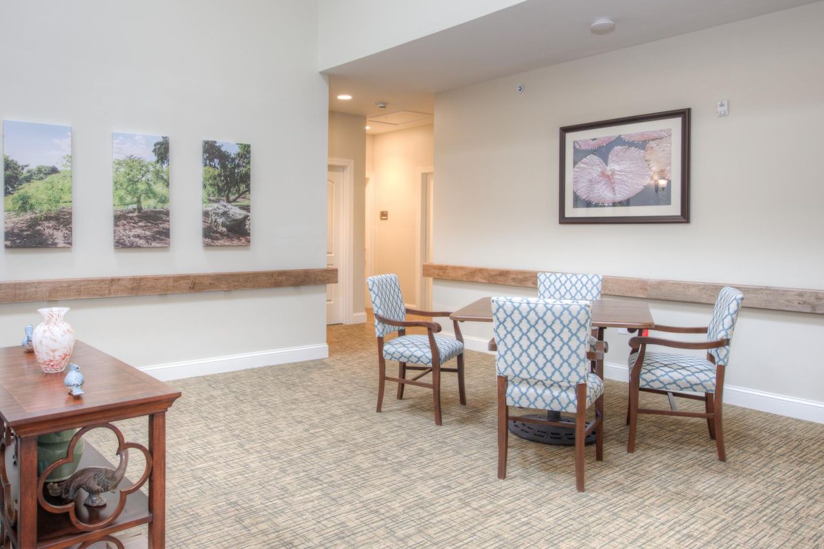 A bright dining area featuring a table and chairs with artwork on the walls.