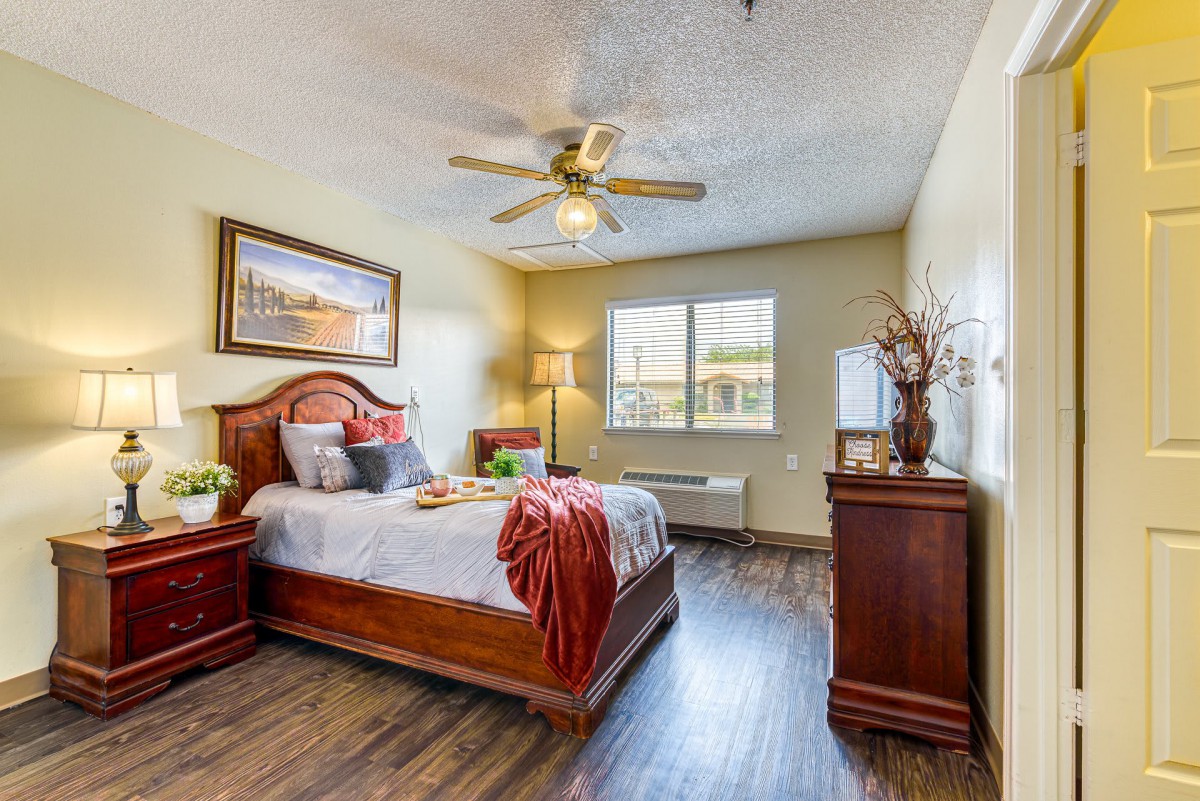 A cozy bedroom featuring wood furniture and warm lighting.