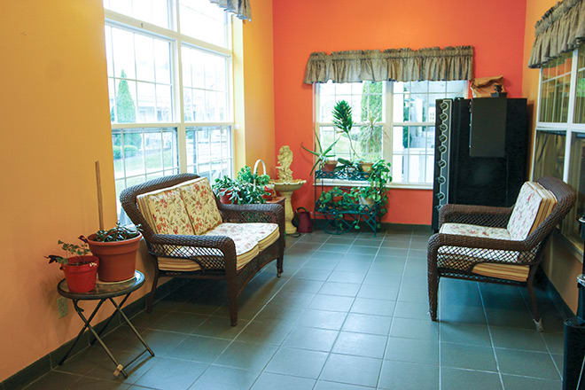 A cozy living room with vibrant walls, large windows, and comfortable seating.