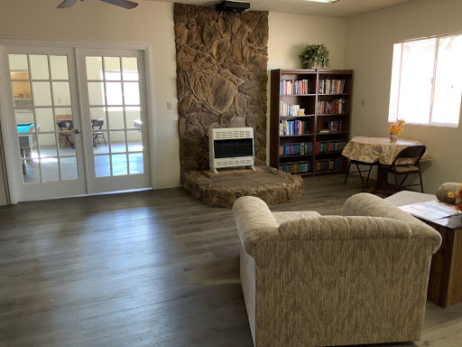 A cozy living room featuring a comfortable sofa, wooden bookshelf, and a decorative fireplace.