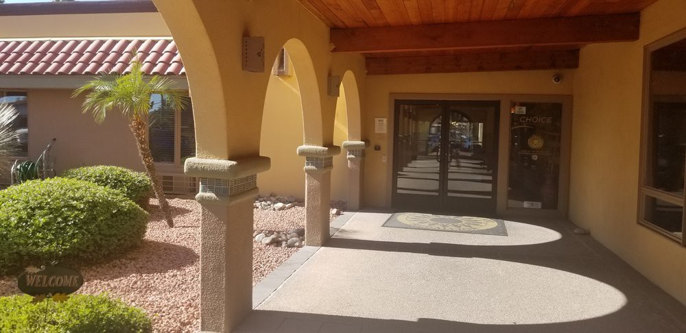 A building entrance with arched columns and a wooden door.