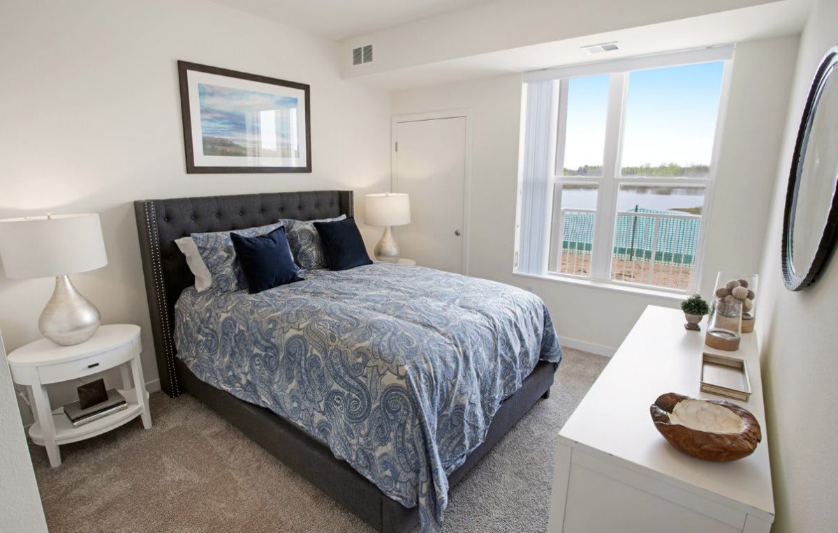A beautifully decorated bedroom with a large bed and bright window.