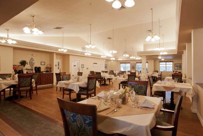 A spacious restaurant dining area with neatly arranged tables and elegant lighting.