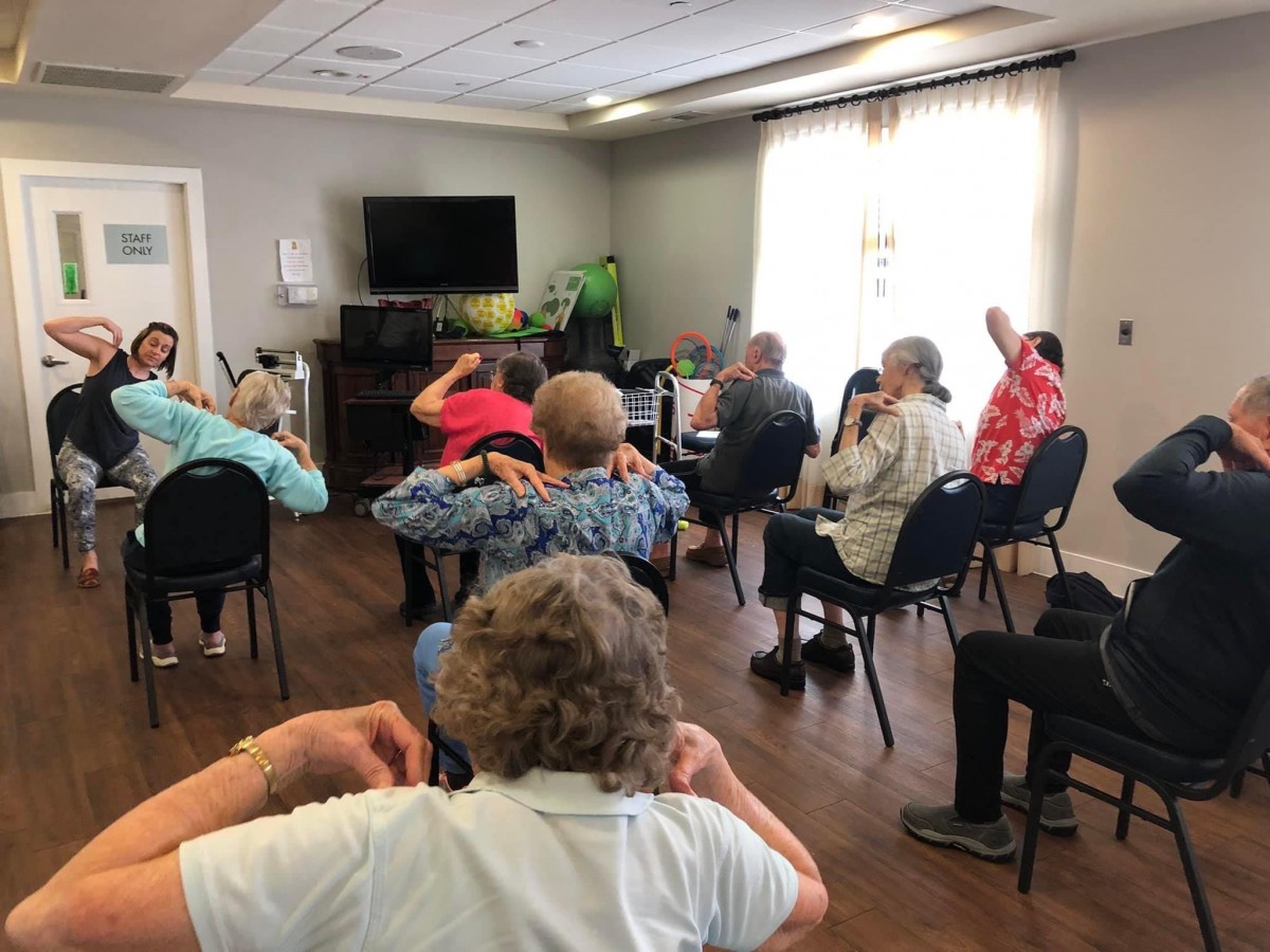A group of seniors participating in an indoor exercise session.